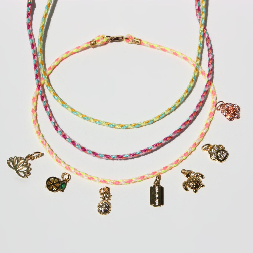 Set of colorful braided bracelets with various charms