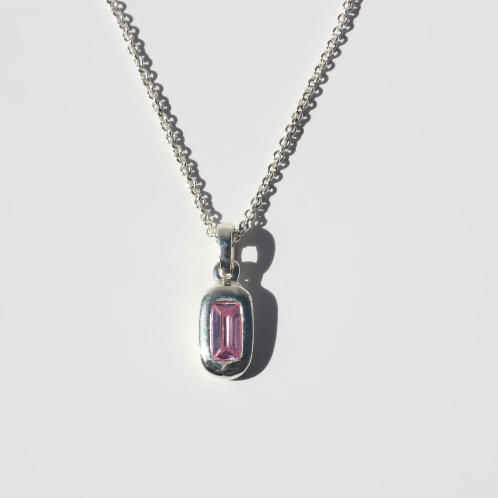 Joyful and Co .999 fine silver baguette pendant necklace with lab grown pink stone on a curb chain.