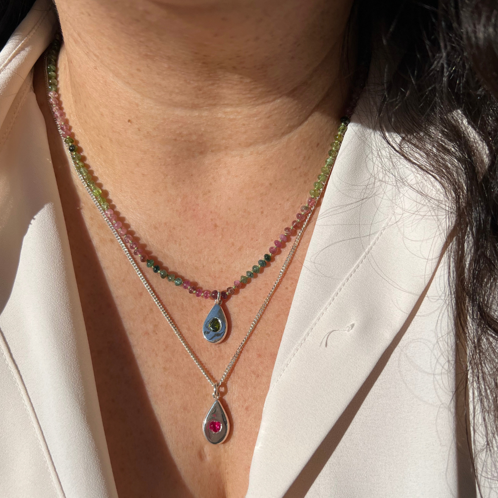 Model Wearing Two Teardrop Pendant necklaces on a Silver Curb chain and on a tourmaline Beaded Necklace.