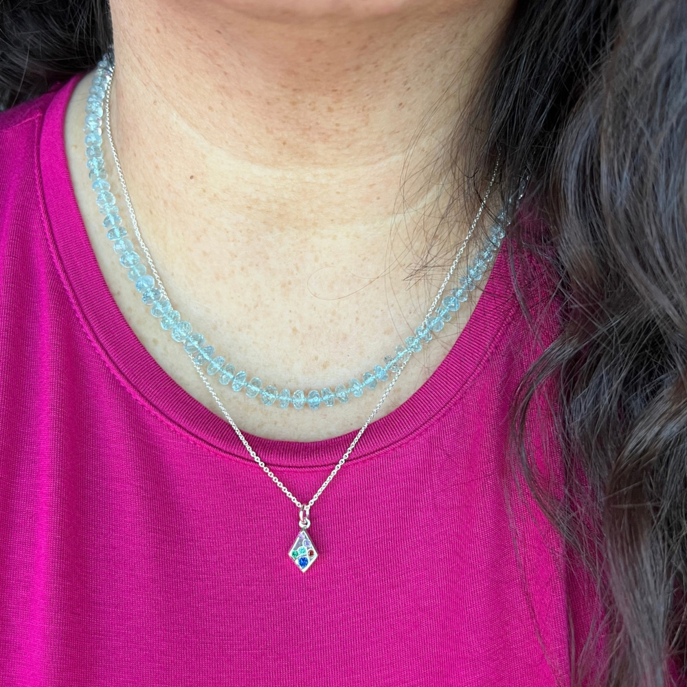 "Model wearing a fine silver sand cast kite gemstone pendant necklace layered with sterling silver chains."