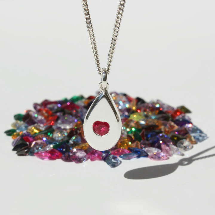 "Joyful and Co .999 fine silver sand cast pear pendant with fuchsia pink heart gemstone on a sterling silver curb chain."